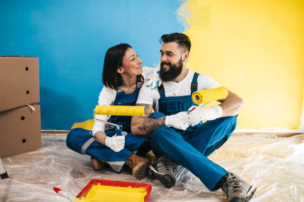 home renovation and wall painting - house painter paint roller yellow painting imagens e fotografias de stock