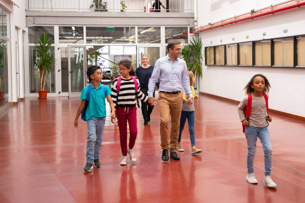 istock Mix raced group of classmates walking through hallway 1290265514