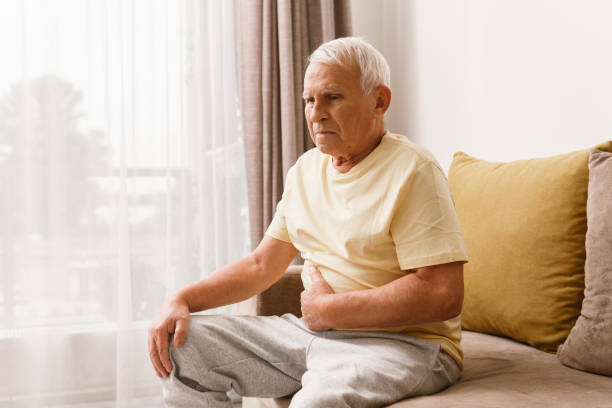 senior mann leidet unter verdauungsproblemen - arthritis senior adult rheumatoid arthritis sadness stock-fotos und bilder