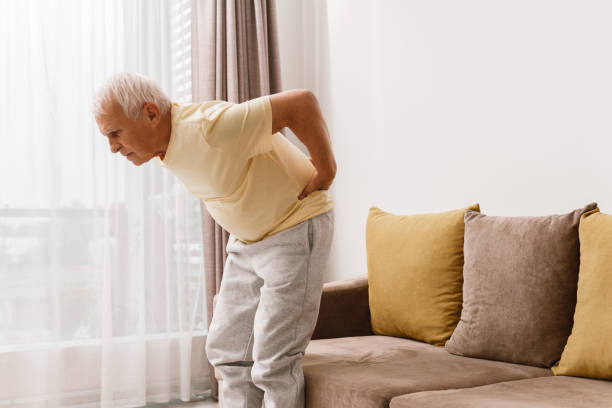 senior mann leidet unter schmerzen im unteren rücken - arthritis senior adult rheumatoid arthritis sadness stock-fotos und bilder