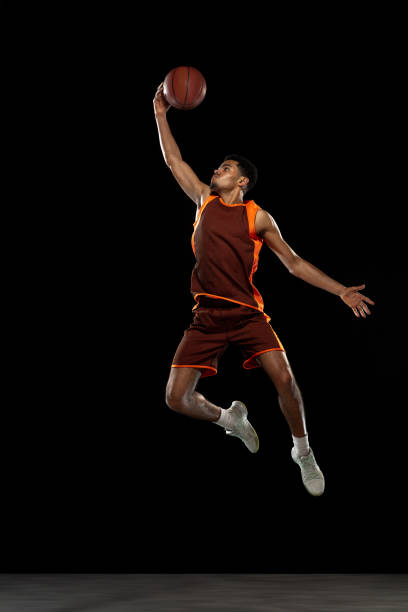 istock Young african basketball player training on black studio background. 1290266871