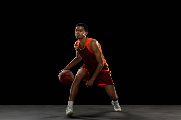 istock Young african basketball player training on black studio background. 1290266881