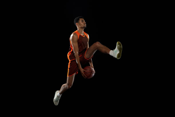 istock Young african basketball player training on black studio background. 1290266890
