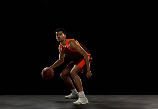 istock Young african basketball player training on black studio background. 1290266908
