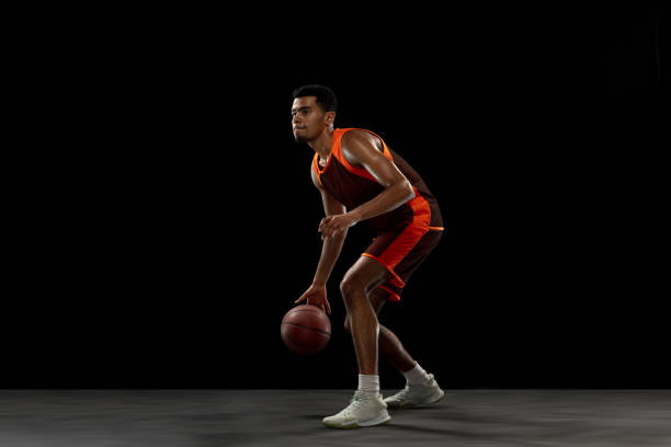 istock Young african basketball player training on black studio background. 1290266916