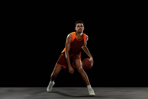 istock Young african basketball player training on black studio background. 1290266923