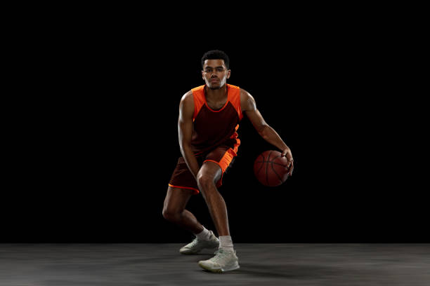 istock Young african basketball player training on black studio background. 1290266931