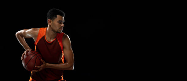 istock Young african basketball player training on black studio background. 1290266957