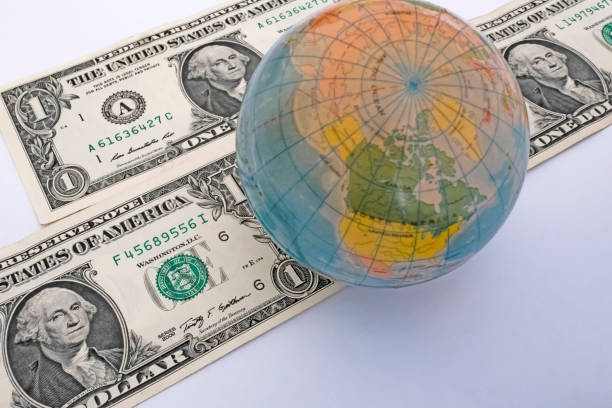 istock Close up US Dollar banknotes with mini earth globe on white background 1290267068