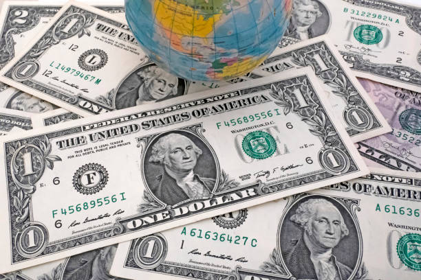 istock Close up US Dollar banknotes with mini earth globe on white background 1290267615