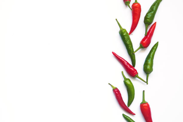 istock green and red hot chili peppers on a white background with space for text. 1290269219