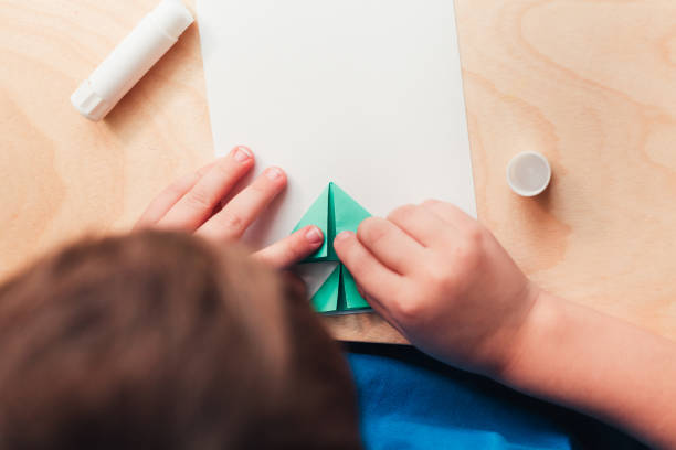 istock Child making Christmas card from paper. Step 5 1290269674
