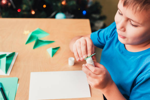 istock Child making Christmas card from paper. Step 5 1290270656