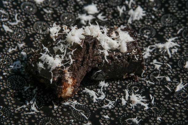 Brownies decorated with coconut flakes on minimalist black plate