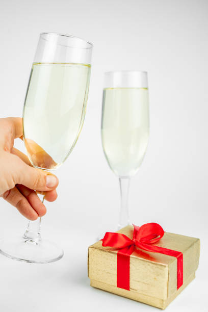 istock Two glasses with champagne and gold gift box on white background 1290270885