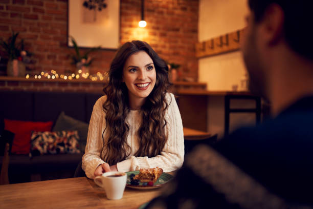istock Happy couple sitting in cafe during Christmas time 1290272642