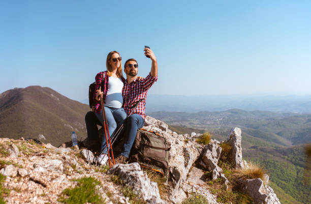 istock Couple take selfie photo on mountain top 1290272823