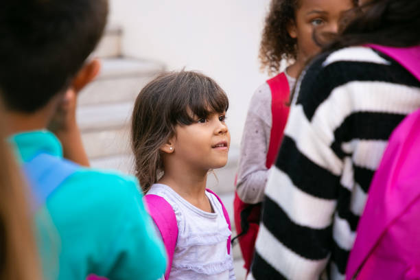 istock Positive primary school student standing among elder schoolkids 1290274753