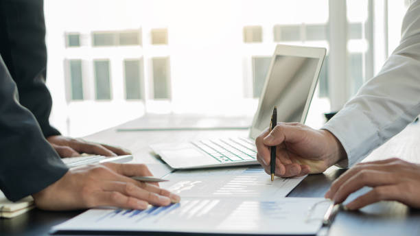 istock Image of two young businessmen reading graphs in a work environment with laptop in a conference room 1290275040