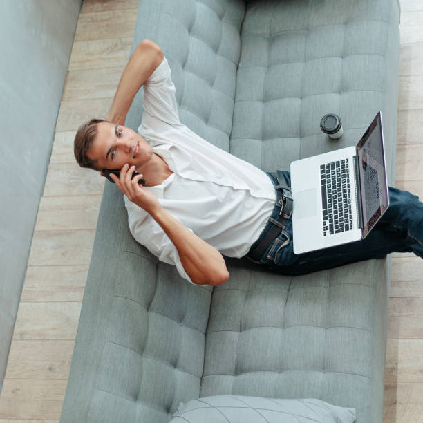 istock young man is talking on a smartphone in his living room 1290275464