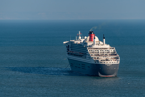 Torquay, UK. Sunday 6 December 2020. Queen Mary 2 cruise liner moored off the Devon coast.