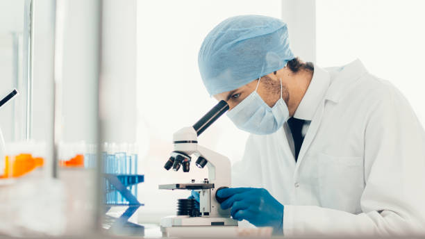 istock close up. scientist looking into the eyepiece of a microscope 1290276570
