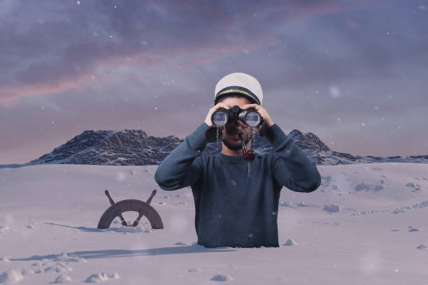 istock shipwrecked helmsman watching with binoculars the mountain and stuck in snow 1290276688