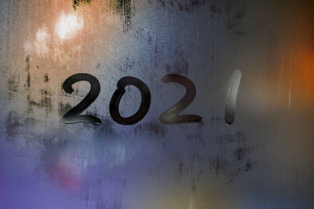 istock digit 2021 handwritten on wet night window glass surface 1290277479