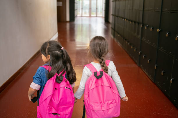 istock Two little schoolgirls with pink backpacks 1290279370
