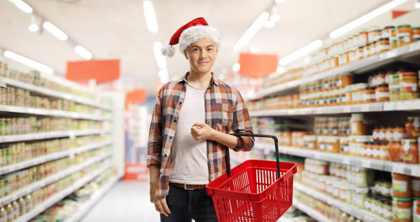 istock Guy in a supermarket wearing a christmas hat 1290280772