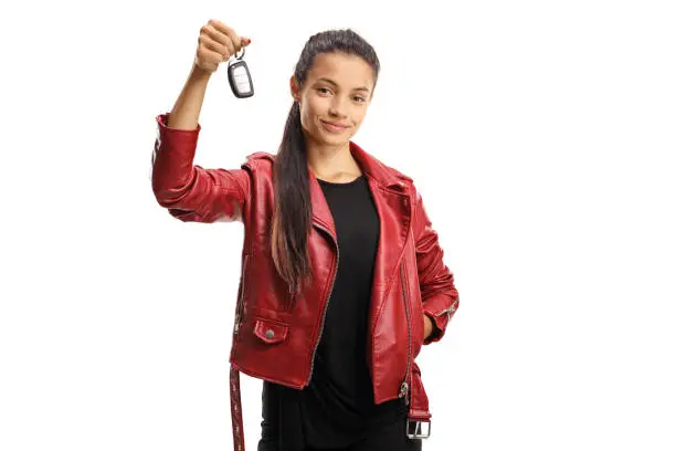 Young mixed race female holding a car key isolated on white background