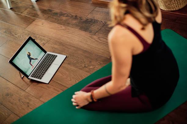 istock A middle-aged yogi woman practicing yoga at home, following online tutorial during corona virus. 1290280864
