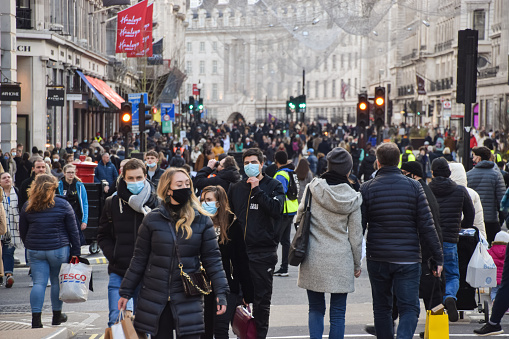 London, United Kingdom - December 5 2020: People wearing protective face masks walking on Regent Street, which was closed to vehicle traffic for a day.
