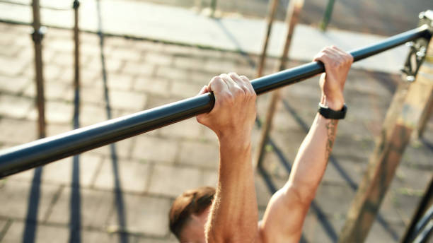 istock Hands of young man on horizontal bar during workout 1290282606
