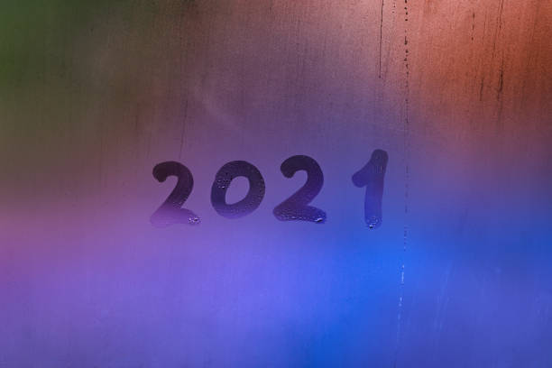 istock digit 2021 handwritten on wet night window glass surface 1290284428