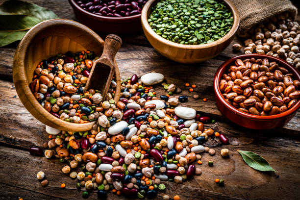 istock Mixed dried legumes spilled from a bowl shot on rustic wooden table 1290284675