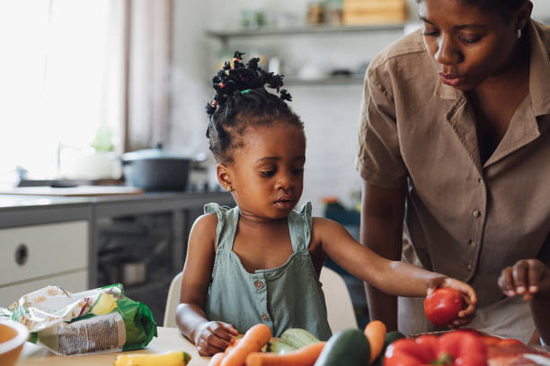 istock Happy Mother, Daughter and Son Preparing Vegetables for Lunch at a Kitchen Table 1290287551