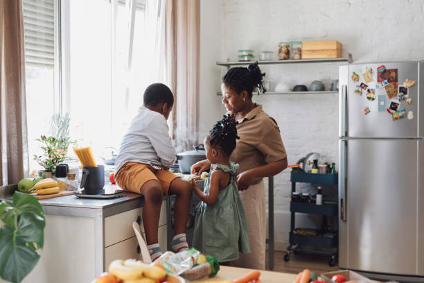 istock Happy Mother, Daughter and Son Preparing Vegetables for Lunch at a Kitchen Table 1290287572