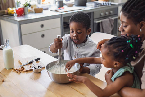 istock Happy Mother, Daughter and Son Preparing Whipped Cream in a Kitchen 1290287587