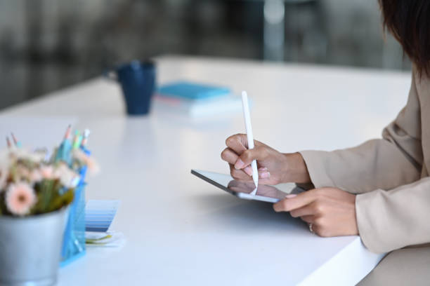 istock Cropped shot of creative designer female using tablet with stylus pen working on a project in office. 1290288192