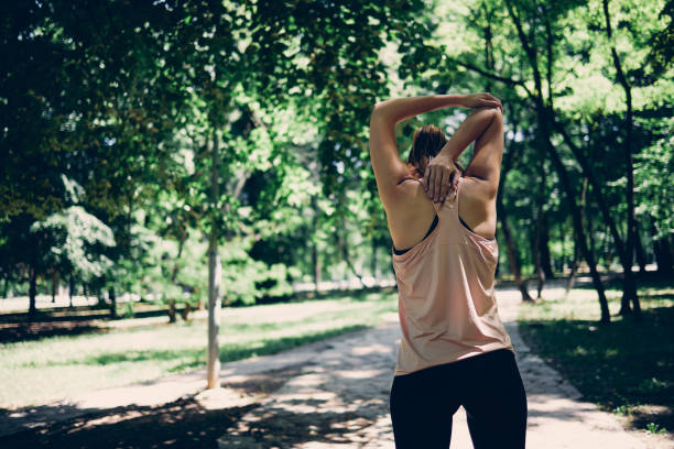 istock Rear view of fit runner doing warmup exercises in nature. 1290288307