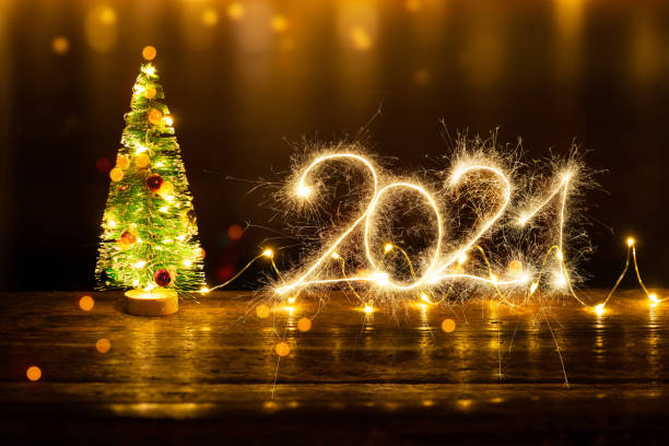 istock Christmas Composition with Christmas tree and Sparkler 2021 on old wooden table 1290291127