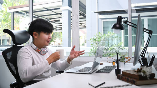 istock A cheerful man with headphone having video conference meeting with computer at home. 1290291927