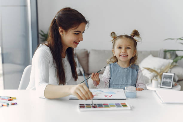 istock Tutor with litthe girl studying at home 1290293196