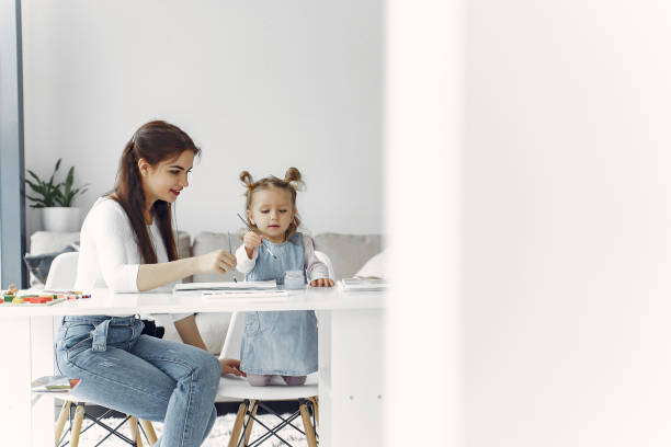 istock Tutor with litthe girl studying at home 1290293206