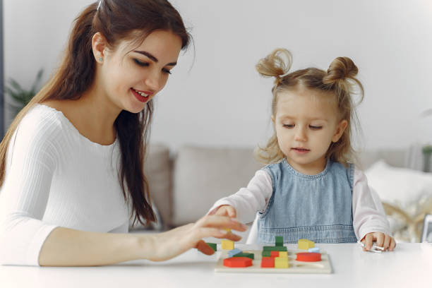 istock Tutor with litthe girl studying at home 1290293261