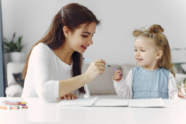 istock Tutor with litthe girl studying at home 1290293333