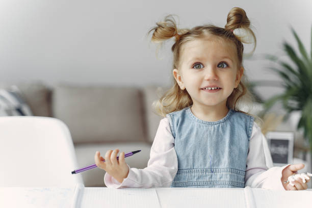 istock Little girl sitting on a table with books 1290293354