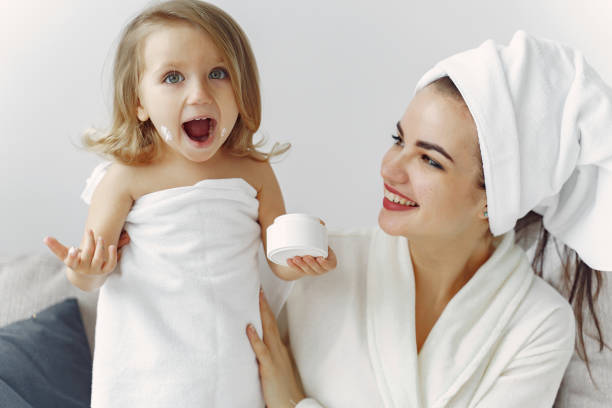 istock Mother with daughter in bathrobe and towels 1290293669