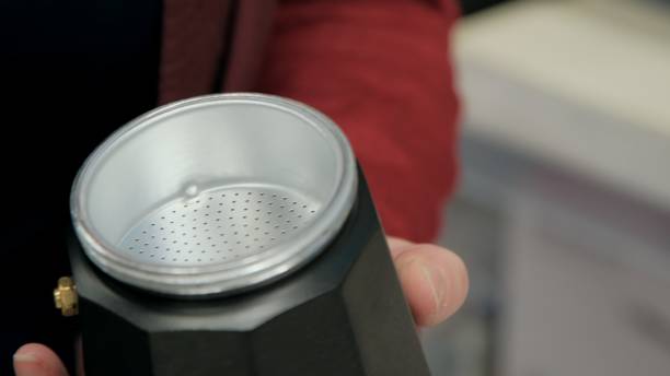 istock Filter from geyser coffee maker in women hands. Closeup shot 1290300711